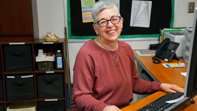 Carole Grandaw sitting at her desk